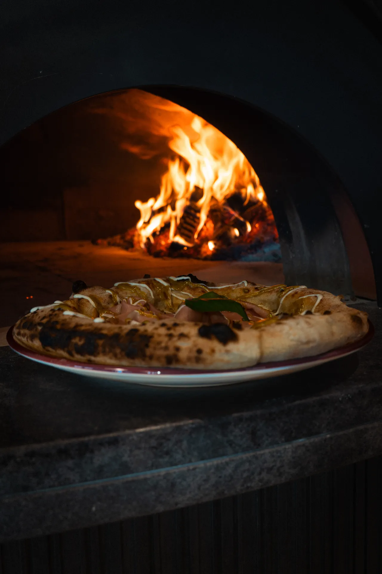 Pizza ispred plamena krušne peći